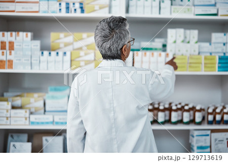 Pharmacy pills, pointing and senior pharmacist with product choice, medicine box or pharmaceutical medication drugs. Retail medical store, healthcare and back of elderly woman point at shop shelf Pharmacy pills, pointing and senior pharmacist with product choice, medicine box or pharmaceutical medication drugs. Retail medical store, healthcare and back of elderly woman point at shop shelf 129713619