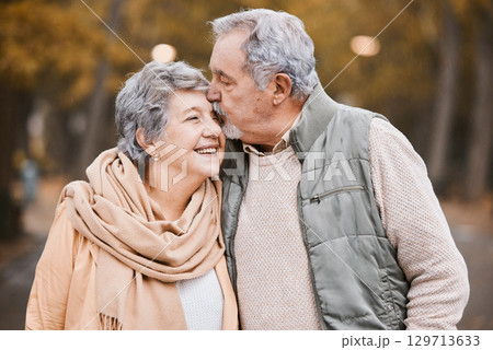 Love, kiss and senior couple in park enjoying weekend, quality time and romantic bonding together. Retirement, relationship and elderly man and woman walking, hugging and embrace outdoors in nature 129713633