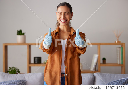 Happy woman, thumbs up and cleaning service with a smile in a house or apartment living room for safety with gloves. Female cleaner showing hand sign to clean dirt, dust and bacteria at home Happy woman, thumbs up and cleaning service with a smile in a house or apartment living room for safety with gloves. Female cleaner showing hand sign to clean dirt, dust and bacteria at home 129713653