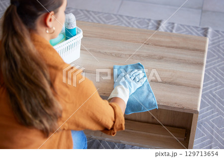 Woman, cleaning and cloth for table in home living room with product, polish or shine on wood. Domestic hygiene expert, wipe and basket to clean in lounge for coffee table, house furniture and focus Woman, cleaning and cloth for table in home living room with product, polish or shine on wood. Domestic hygiene expert, wipe and basket to clean in lounge for coffee table, house furniture and focus 129713654