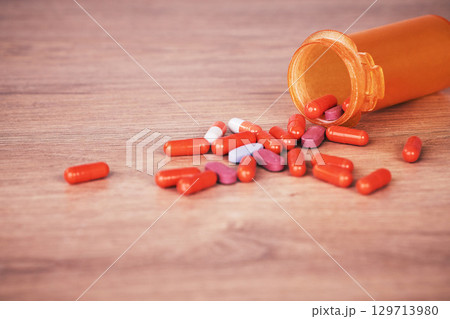 Medicine, pills and healthcare with supplements or vitamin tablets for health with pill zoom on wood table. Healthy, health insurance and prescription medication with medical care and pharmaceutical 129713980