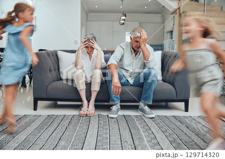 Burnout headache, children running and parents on living room sofa with migraine from hyper active kids. Mental health problem, family stress and senior grandparents tired from babysitting adhd girl Burnout headache, children running and parents on living room sofa with migraine from hyper active kids. Mental health problem, family stress and senior grandparents tired from babysitting adhd girl 129714320