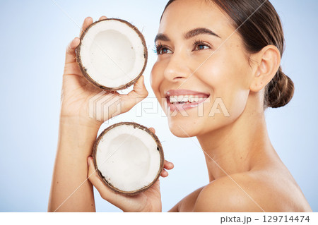 Skincare, wellness and face of woman with coconut on blue background for dermatology, body care and beauty. Spa, salon and girl with fruit for natural beauty products, cosmetics and facial treatment Skincare, wellness and face of woman with coconut on blue background for dermatology, body care and beauty. Spa, salon and girl with fruit for natural beauty products, cosmetics and facial treatment 129714474