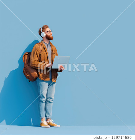 A full-length portrait of a student or modern digital professional. The image conveys a sense of creativity, technology, and learning, with a vibrant, clean background for copy space 129714680