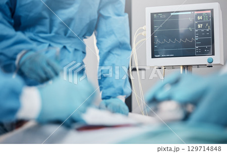 Hands, monitor and operation with a team of doctors at work during surgery with equipment or a tool in a hospital. Doctor, nurse and collaboration with a medicine professional group saving a life 129714848