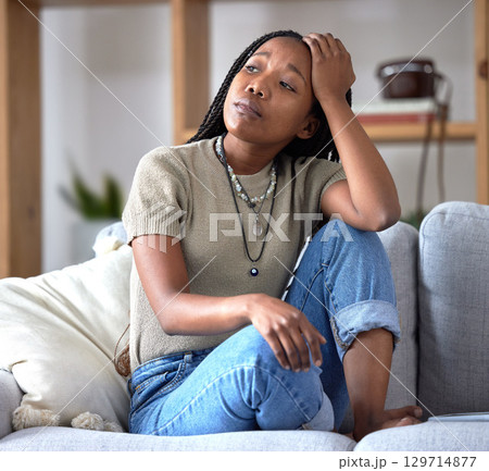 Black woman, sofa and stress with worry, thinking and sad in home living room with fear of future. African woman, sitting and lounge couch with anxiety, depression or mental health problem in Chicago 129714877