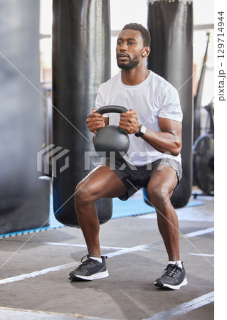 Black man, gym and kettlebell for squat exercise, weightlifting workout or muscle growth training. African bodybuilder, wellness trainer and metal weights for strong legs, body development or health Black man, gym and kettlebell for squat exercise, weightlifting workout or muscle growth training. African bodybuilder, wellness trainer and metal weights for strong legs, body development or health 129714944