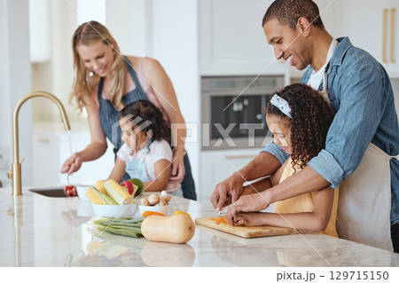 Family, mother and father with girls, vegetables or cooking together, interracial or bonding. Love, man and woman happy with daughters, cutting or rinse veggies in kitchen, child development or relax 129715150
