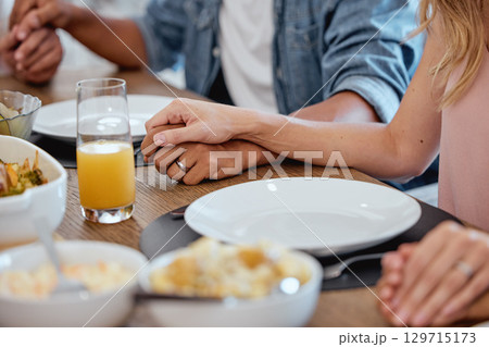 Holding hands, praying and food with a family grace around the dinner table during a thanksgiving celebration. Prayer, trust and love with a group of people enjoying lunch during a social gathering Holding hands, praying and food with a family grace around the dinner table during a thanksgiving celebration. Prayer, trust and love with a group of people enjoying lunch during a social gathering 129715173