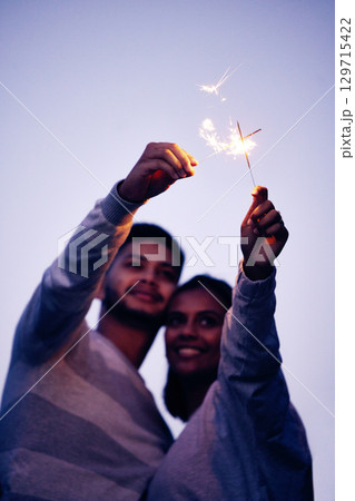 Couple, sparklers and happy together for night celebration or romance date for love, support and freedom outdoor. Smile, Indian woman and man hugging or quality time to celebrate happiness in Bali 129715422