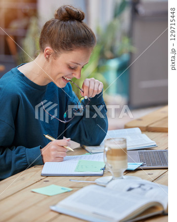 Woman, laptop and notebook writing in cafe, coffee shop or restaurant for university, college or school study. Smile, happy or elearning student with education technology in remote research homework Woman, laptop and notebook writing in cafe, coffee shop or restaurant for university, college or school study. Smile, happy or elearning student with education technology in remote research homework 129715448