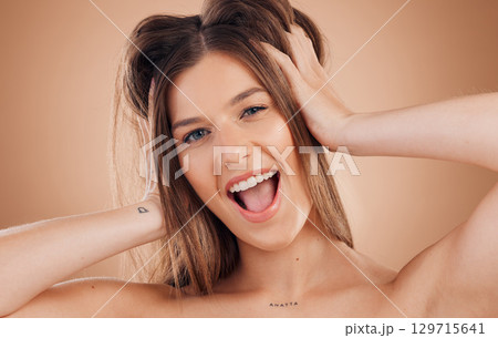 Woman, beauty and smile for hair, skincare or treatment against a brown studio background. Portrait of happy and excited female smiling in happiness or satisfaction for perfect skin or facial care 129715641