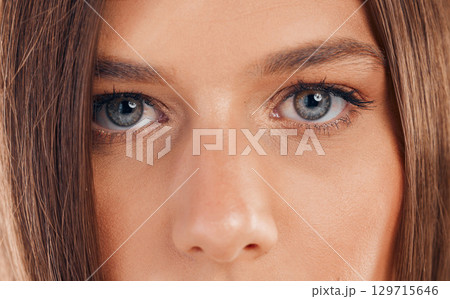 Woman, eyes and face in vision for sight, beauty or awareness staring with facial cosmetics or makeup. Closeup portrait of female looking in eyesight, skincare or microblading eyebrows and eyelashes 129715646