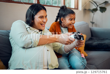 Family, video game and online gaming on home sofa with a pregnant mother and daughter on a living room couch together while happy and having fun. Woman and girl kid together for esports competition Family, video game and online gaming on home sofa with a pregnant mother and daughter on a living room couch together while happy and having fun. Woman and girl kid together for esports competition 129715761