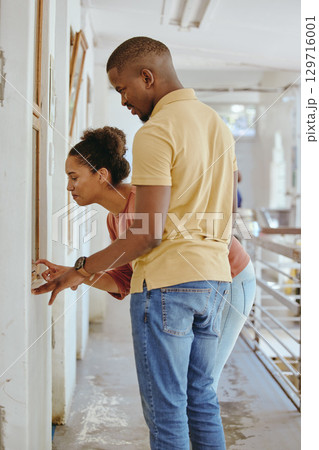 Adoption, animal shelter and charity with a black couple in a rescue center for the foster care of a pet. Community, volunteer and empathy with a man and woman looking for pets at a kennel to adopt 129716001