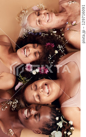 Top view, women diversity or faces with flowers on studio background in empowerment, divine feminine energy or self love. Smile, happy or skincare beauty models with plants, leaf or organic spa glow Top view, women diversity or faces with flowers on studio background in empowerment, divine feminine energy or self love. Smile, happy or skincare beauty models with plants, leaf or organic spa glow 129716091