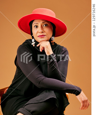 Black woman, islamic fashion portrait and serious face for beauty, trendy designer wear and modern muslim. Senior woman, trendy arabic lifestyle and culture or religion in brown studio background 129716246