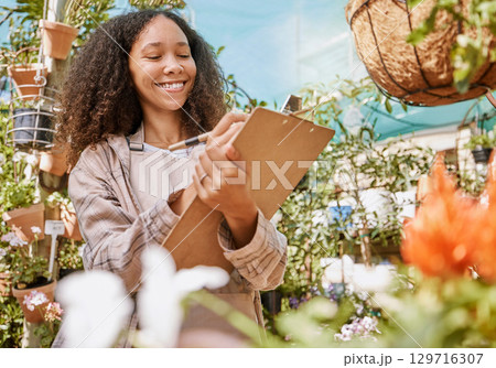Small business, plants and black woman with inventory, quality control and checklist clipboard in nursery. Smile of satisfied business owner writing quality assurance notes in flower garden. 129716307