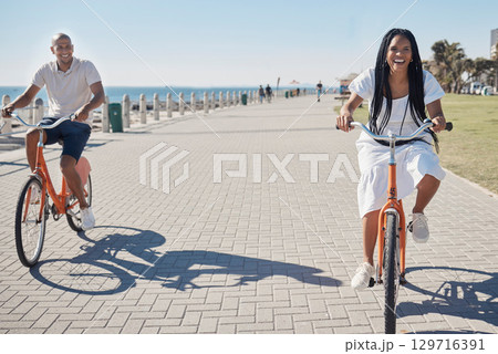 Travel, summer and couple on bike at beach for date on promenade in Chicago, USA sunshine with smile. Freedom, fun and happy black people at ocean with bicycle for wellness, bonding and fitness. Travel, summer and couple on bike at beach for date on promenade in Chicago, USA sunshine with smile. Freedom, fun and happy black people at ocean with bicycle for wellness, bonding and fitness. 129716391