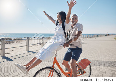 Bicycle, beach and couple with freedom, travel and summer holiday in city sidewalk for wellness, love and care in sunshine. Mental health, black woman and cycling partner at ocean on blue sky mockup Bicycle, beach and couple with freedom, travel and summer holiday in city sidewalk for wellness, love and care in sunshine. Mental health, black woman and cycling partner at ocean on blue sky mockup 129716394