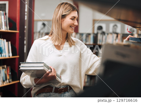 University library and woman student with books for knowledge, studying and research. College girl at bookshelf thinking, happy and excited with choice of literature in academic facility. 129716616