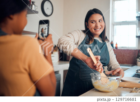 Baking, tutorial and social media with a chef woman in the kitchen of her home cooking as an influencer. Food, phone and vlog with a female cook preparing baked goods while live streaming in a house Baking, tutorial and social media with a chef woman in the kitchen of her home cooking as an influencer. Food, phone and vlog with a female cook preparing baked goods while live streaming in a house 129716681