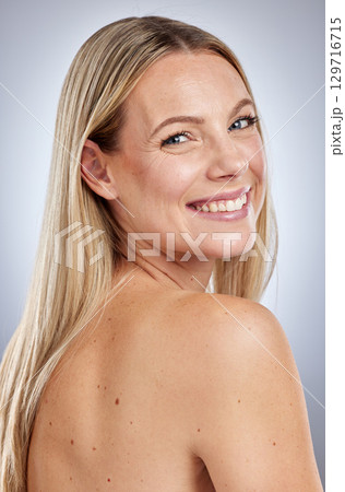 Portrait, woman and skincare for cosmetics, health and wellness on grey studio background. Smile, female and lady with natural beauty, smooth and soft skin for confidence, body care and face detox. 129716715
