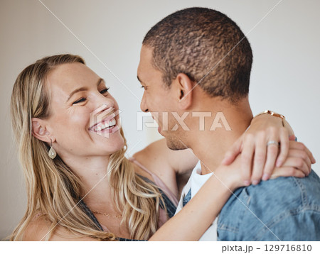 Love, hug and smile with a diversity couple in studio on a gray background for romance or affection. Trust, safe and together with a man and woman hugging while bonding, dating or loving 129716810