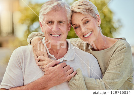 Portrait, love and retirement with a senior couple hugging outdoor in nature together during summer. Happy, smile and park with an elderly man and woman pensioner bonding outside on a romantic date 129716834