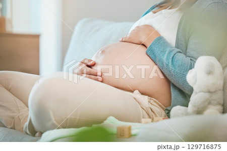 Pregnant, stomach and mother bond with her baby while resting during maternity at home. Tummy, belly and pregnancy with a mommy to be holding her abdomen and caring for her kid while relaxing Pregnant, stomach and mother bond with her baby while resting during maternity at home. Tummy, belly and pregnancy with a mommy to be holding her abdomen and caring for her kid while relaxing 129716875