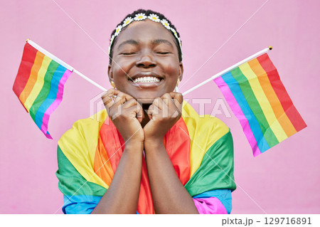 Pride, lgbtq and black woman with flags in studio for queer rights. Freedom, homosexual and face of happy, lesbian or bisexual female from Nigeria with rainbow flag showing support for gay community. 129716891