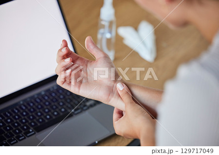 Wrist, pain and woman at laptop working with injury, arthritis or carpal tunnel syndrome concern. Inflammation, uncomfortable and injured girl with medical problem at table with screen mockup. 129717049