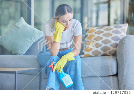 Tired, thinking and woman cleaning home on break with fatigue, unhappy and frustrated with routine. Spring cleaning, burnout and exhausted girl holding detergent spray thoughtful on lounge sofa. Tired, thinking and woman cleaning home on break with fatigue, unhappy and frustrated with routine. Spring cleaning, burnout and exhausted girl holding detergent spray thoughtful on lounge sofa. 129717056
