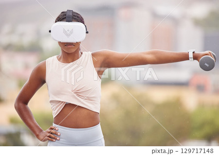 Virtual reality, fitness or black woman with a dumbbell, vr or 3d headset for a gaming experience with exercise. Metaverse, gamer or sports girl gaming or training in futuristic ai digital technology Virtual reality, fitness or black woman with a dumbbell, vr or 3d headset for a gaming experience with exercise. Metaverse, gamer or sports girl gaming or training in futuristic ai digital technology 129717148