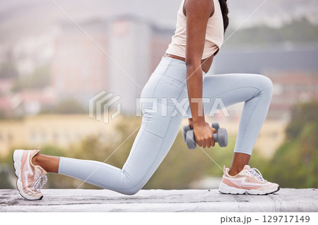 Fitness, woman legs and dumbbells for weightlifting outdoor, weights and body building with training in urban cityscape. Exercise, workout in city and lunges with strong athlete and health wellness. Fitness, woman legs and dumbbells for weightlifting outdoor, weights and body building with training in urban cityscape. Exercise, workout in city and lunges with strong athlete and health wellness. 129717149