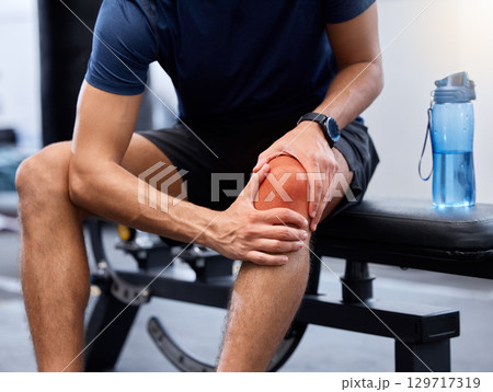 Exercise, man and knee pain in gym, bench and injury after practice, workout and fitness. Healthy male, athlete and training for wellness, healthcare and muscle tension with intense joint strain. Exercise, man and knee pain in gym, bench and injury after practice, workout and fitness. Healthy male, athlete and training for wellness, healthcare and muscle tension with intense joint strain. 129717319