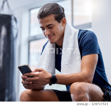 Fitness, phone and man relax in gym tracking workout, exercise or progress on app. Tech, sports and happy male with towel and mobile smartphone for internet browsing, text messaging or social media. Fitness, phone and man relax in gym tracking workout, exercise or progress on app. Tech, sports and happy male with towel and mobile smartphone for internet browsing, text messaging or social media. 129717321