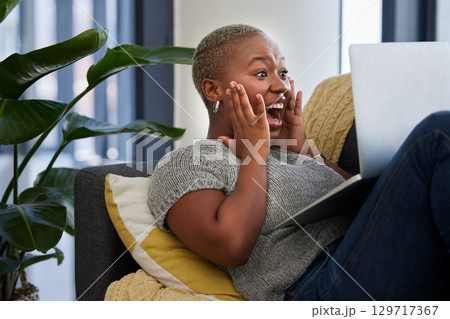 Laptop, surprise and excited black woman on sofa shocked with win of digital lottery, competition or award. Wow news, prize winner and girl on gambling website play online poker, bingo or casino game Laptop, surprise and excited black woman on sofa shocked with win of digital lottery, competition or award. Wow news, prize winner and girl on gambling website play online poker, bingo or casino game 129717367