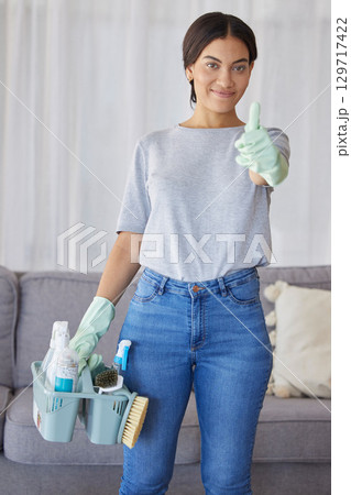 Cleaner, thumbs up and portrait of a woman with supplies to clean the living room of a house. Happy, smile and female maid or housewife with a positive mindset for cleaning an apartment, loft or home 129717422