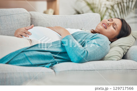 Pregnant, pain and woman in labor with stomach pain and childbirth at family home, new mom and pregnancy emergency. Health, prenatal care and medical, breathing and abdomen ache with pregnant woman. 129717566