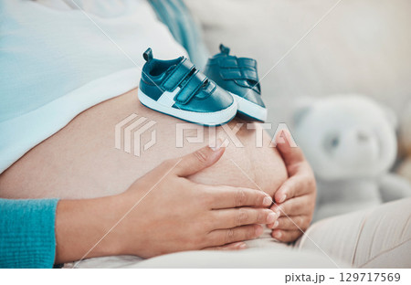 Mother with pregnant stomach in hands, shoes for baby with pregnancy, relax and waiting for birth with love and hope for healthy child. Woman, prenatal care and mom at family home, ready for newborn. Mother with pregnant stomach in hands, shoes for baby with pregnancy, relax and waiting for birth with love and hope for healthy child. Woman, prenatal care and mom at family home, ready for newborn. 129717569