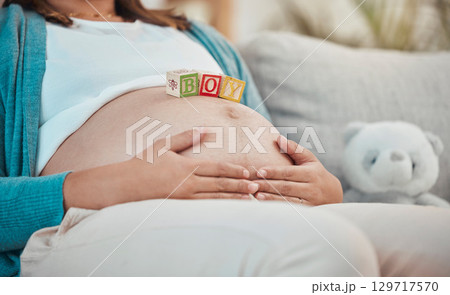 Mother, stomach and toys with a boy baby for expecting mother relaxing at home on the sofa. Child, announcement and pregnancy notification with a woman with wood blocks on her belly for a son 129717570