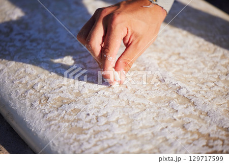 Hand, surfboard and wax with a sports man outdoor at the beach for surfing or recreation during summer. Fitness, surf and maintenance with a male surfer or athlete outside on the coast for surfing Hand, surfboard and wax with a sports man outdoor at the beach for surfing or recreation during summer. Fitness, surf and maintenance with a male surfer or athlete outside on the coast for surfing 129717599