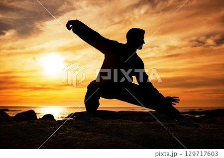 Karate man, silhouette and tai chi with sunset sky on beach horizon for martial arts, taekwondo or fight exercise, training or practice. Art deco of athlete at sea for nature workout and fitness Karate man, silhouette and tai chi with sunset sky on beach horizon for martial arts, taekwondo or fight exercise, training or practice. Art deco of athlete at sea for nature workout and fitness 129717603