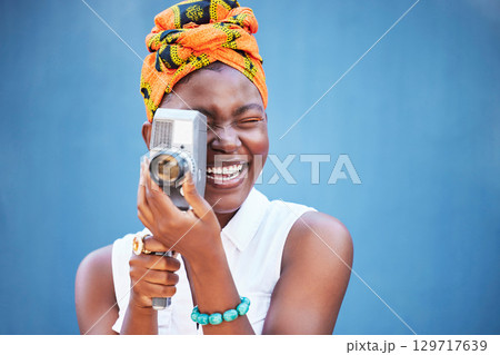 Face, photographer and black woman with camera in studio isolated on a blue mock up background. Photography, tech and happy female from Nigeria with camcorder taking pictures, photo or photographs. Face, photographer and black woman with camera in studio isolated on a blue mock up background. Photography, tech and happy female from Nigeria with camcorder taking pictures, photo or photographs. 129717639