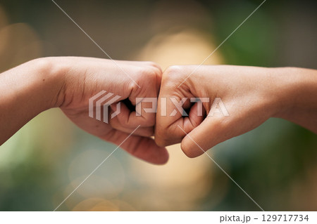 Closeup fist bump, hands and greeting for friends, team or support for power, solidarity or touch. Hand connection, teamwork and motivation with knuckle, friendship and together by blurred background Closeup fist bump, hands and greeting for friends, team or support for power, solidarity or touch. Hand connection, teamwork and motivation with knuckle, friendship and together by blurred background 129717734