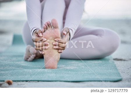 Beach yoga, foot and woman stretching for warm up exercise, outdoor pilates fitness or training for body health. Wellness lifestyle, sand and feet of healthy girl start workout performance for sports Beach yoga, foot and woman stretching for warm up exercise, outdoor pilates fitness or training for body health. Wellness lifestyle, sand and feet of healthy girl start workout performance for sports 129717770