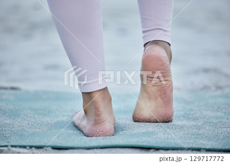 Woman in yoga stretching feet at a beach training legs in a holistic foot exercise or workout in nature. Fitness, wellness or spiritual zen girl exercising for balance or healthy strong body alone Woman in yoga stretching feet at a beach training legs in a holistic foot exercise or workout in nature. Fitness, wellness or spiritual zen girl exercising for balance or healthy strong body alone 129717772