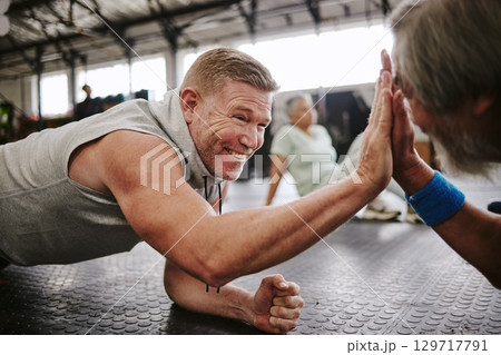 Exercise, old men on floor and high five for achievement, fitness goals or happiness in gym. Mature male athletes, senior citizens or gesture for celebration, workout target or on ground for training 129717791