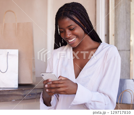 Black woman, smartphone and shopping, happy and communication, retail and sale with bargain, discount with technology. Phone, shopping bag in mall and social media, text message and mobile app. Black woman, smartphone and shopping, happy and communication, retail and sale with bargain, discount with technology. Phone, shopping bag in mall and social media, text message and mobile app. 129717810